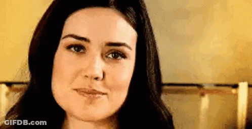 A Close Up Of A Woman 'S Face With Long Dark Hair . GIF