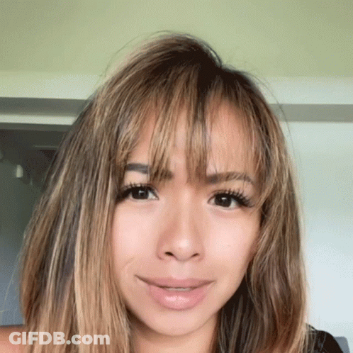 A Close Up Of A Woman 'S Face With Long Hair GIF