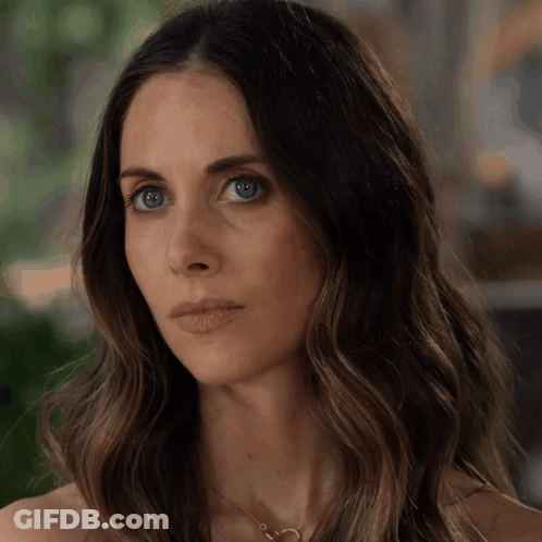 A Close Up Of A Woman 'S Face With Long Hair GIF
