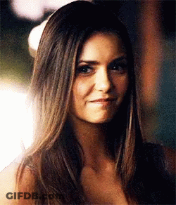 A Close Up Of A Woman 'S Face With Long Hair And A Smile . GIF