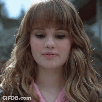 A Close Up Of A Woman 'S Face With Long Hair And Bangs GIF