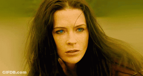 A Close Up Of A Woman 'S Face With Long Hair And Blue Eyes GIF