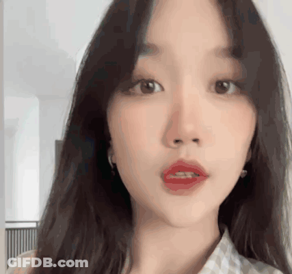 A Close Up Of A Woman 'S Face With Long Hair And Red Lips GIF