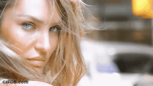 A Close Up Of A Woman 'S Face With Long Hair Blowing In The Wind . GIF