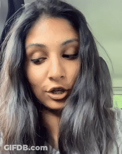 A Close Up Of A Woman 'S Face With Long Hair GIF
