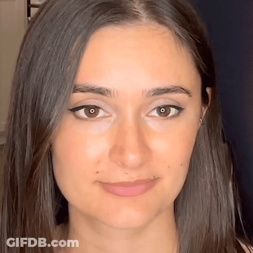 A Close Up Of A Woman 'S Face With Long Hair GIF