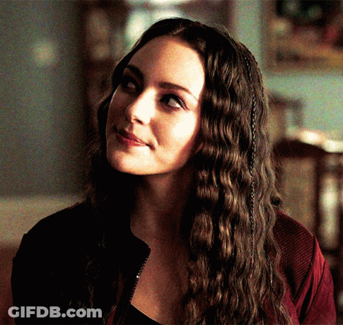 A Close Up Of A Woman 'S Face With Long Hair GIF