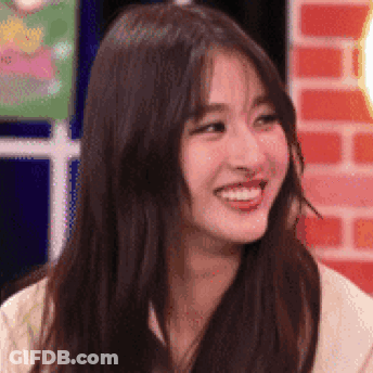 A Close Up Of A Woman 'S Face With Long Hair Smiling . GIF