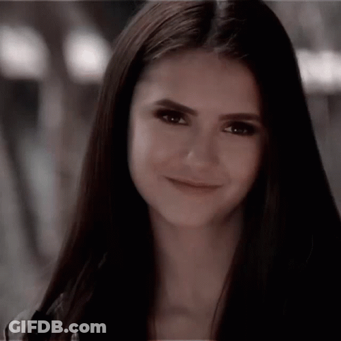 A Close Up Of A Woman 'S Face With Long Hair Smiling . GIF