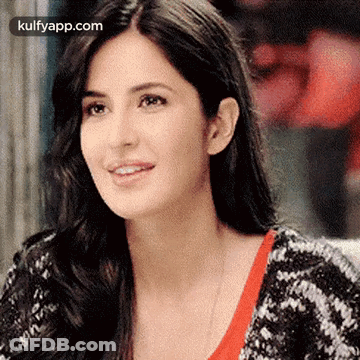 A Close Up Of A Woman 'S Face With Long Hair Wearing A Black And White Sweater . GIF