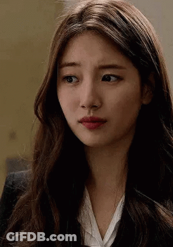 A Close Up Of A Woman 'S Face With Long Hair Wearing A Suit And White Shirt . GIF