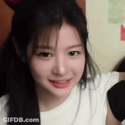 A Close Up Of A Woman 'S Face With Long Hair Wearing A White Shirt . GIF