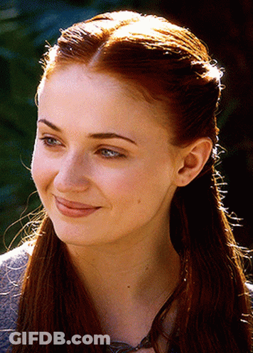 A Close Up Of A Woman 'S Face With Long Red Hair GIF