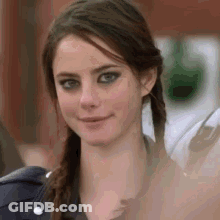 A Close Up Of A Woman 'S Face With Pigtails Smiling . GIF