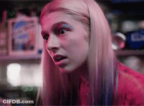 A Close Up Of A Woman 'S Face With Pink And Blue Makeup GIF