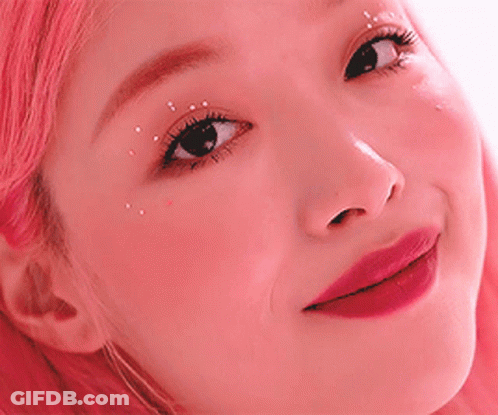 A Close Up Of A Woman 'S Face With Pink Hair . GIF