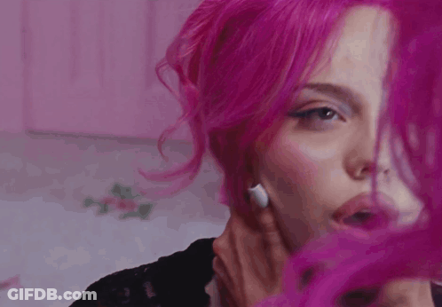 A Close Up Of A Woman 'S Face With Pink Hair GIF