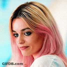 A Close Up Of A Woman 'S Face With Pink Hair GIF