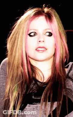 A Close Up Of A Woman 'S Face With Pink Hair GIF