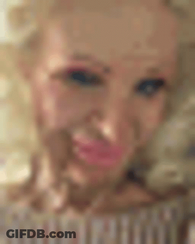 A Close Up Of A Woman 'S Face With Pink Lips And A Tattoo On Her Forehead . GIF