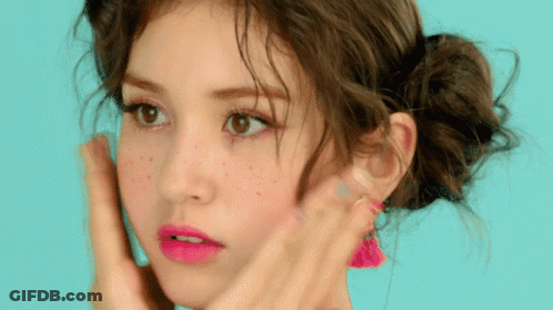 A Close Up Of A Woman 'S Face With Pink Lipstick And Freckles GIF