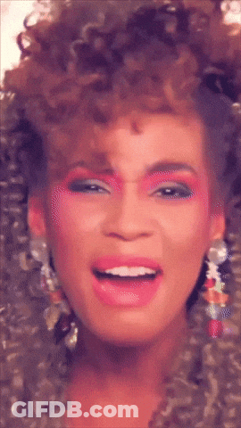 A Close Up Of A Woman 'S Face With Pink Makeup And Earrings GIF
