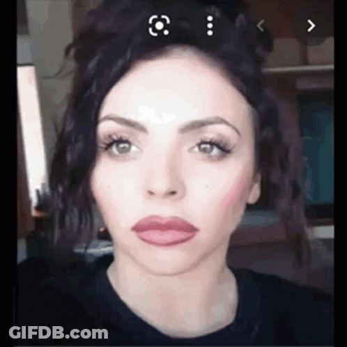 A Close Up Of A Woman 'S Face With Purple Hair . GIF