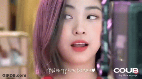 A Close Up Of A Woman 'S Face With Purple Hair Making A Funny Face . GIF