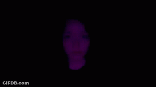 A Close Up Of A Woman 'S Face With Purple Lights Behind Her . GIF