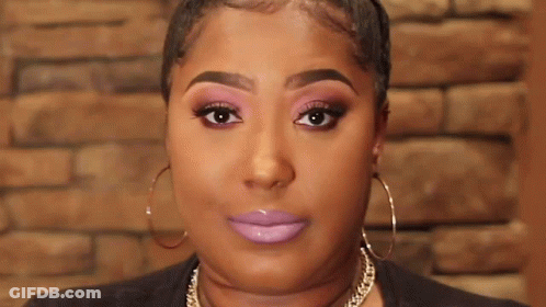 A Close Up Of A Woman 'S Face With Purple Lipstick And Hoop Earrings . GIF