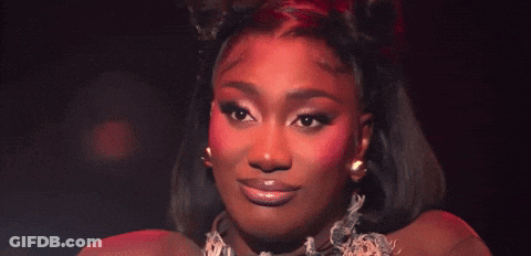 A Close Up Of A Woman 'S Face With Red Eye Shadow GIF