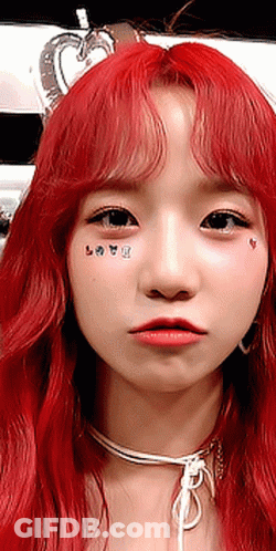 A Close Up Of A Woman 'S Face With Red Hair And A Choker GIF