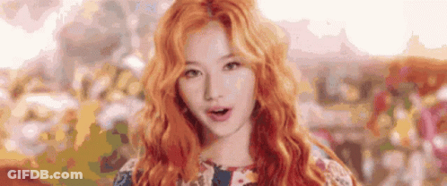 A Close Up Of A Woman 'S Face With Red Hair And A Floral Dress . GIF