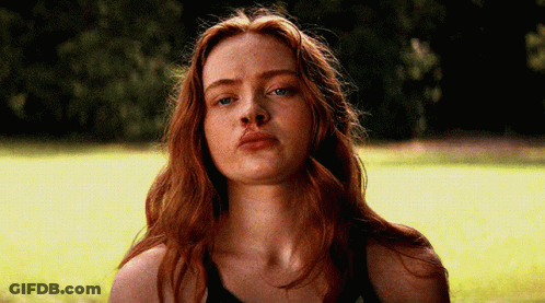 A Close Up Of A Woman 'S Face With Red Hair And Blue Eyes GIF