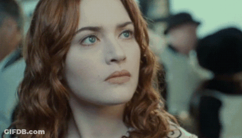 A Close Up Of A Woman 'S Face With Red Hair And Green Eyes GIF