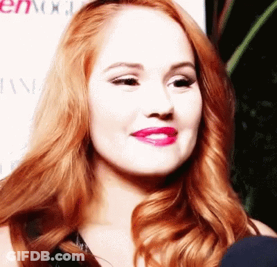 A Close Up Of A Woman 'S Face With Red Hair And Pink Lips GIF