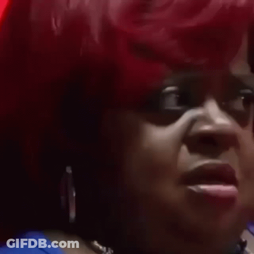 A Close Up Of A Woman 'S Face With Red Hair Making A Funny Face . GIF