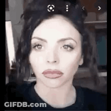 A Close Up Of A Woman 'S Face With Red Lips And A Black Shirt . GIF