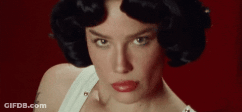 A Close Up Of A Woman 'S Face With Red Lips And Black Hair On A Red Background . GIF