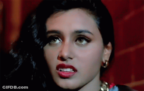 A Close Up Of A Woman 'S Face With Red Lips And Gold Earrings GIF