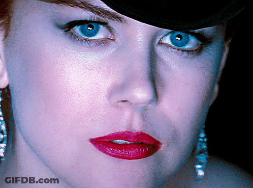 A Close Up Of A Woman 'S Face With Red Lipstick And Blue Eyes GIF