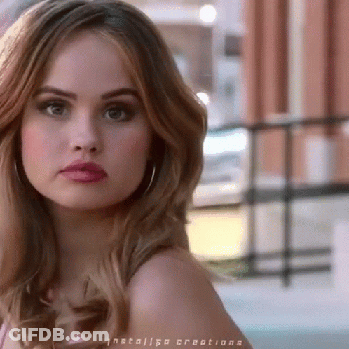 A Close Up Of A Woman 'S Face With Red Lipstick And Hoop Earrings GIF