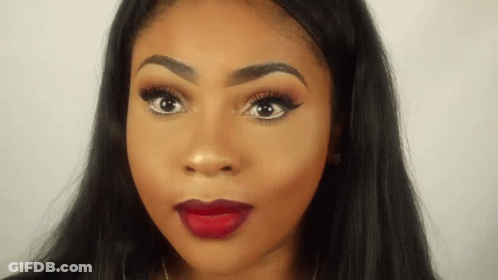 A Close Up Of A Woman 'S Face With Red Lipstick And Long Black Hair . GIF