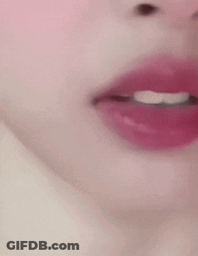 A Close Up Of A Woman 'S Face With Red Lipstick And White Teeth GIF