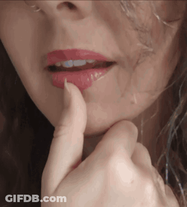 A Close Up Of A Woman 'S Face With Red Lipstick On Her Lips GIF