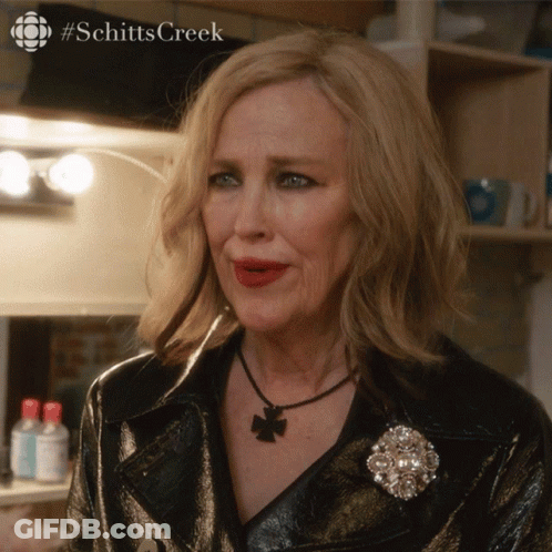 A Close Up Of A Woman 'S Face With #Schitts Creek Written On The Bottom GIF