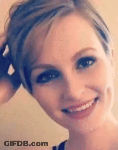 A Close Up Of A Woman 'S Face With Short Hair And A Smile On Her Face . GIF