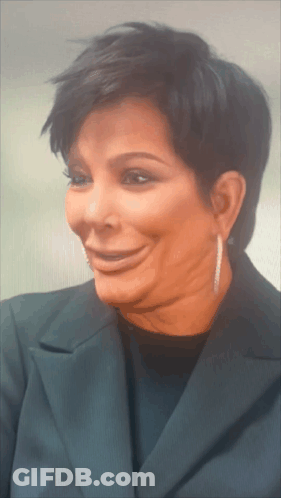 A Close Up Of A Woman 'S Face With Short Hair And Earrings GIF