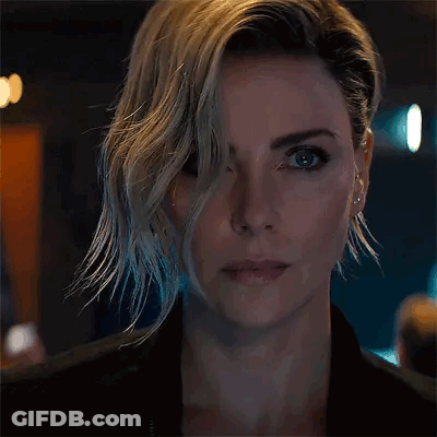 A Close Up Of A Woman 'S Face With Short Hair And Earrings GIF