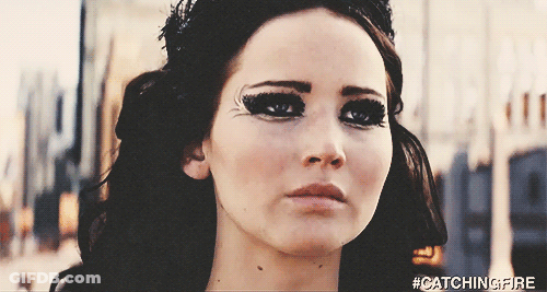 A Close Up Of A Woman 'S Face With The Hashtag #Catchingfire On It GIF